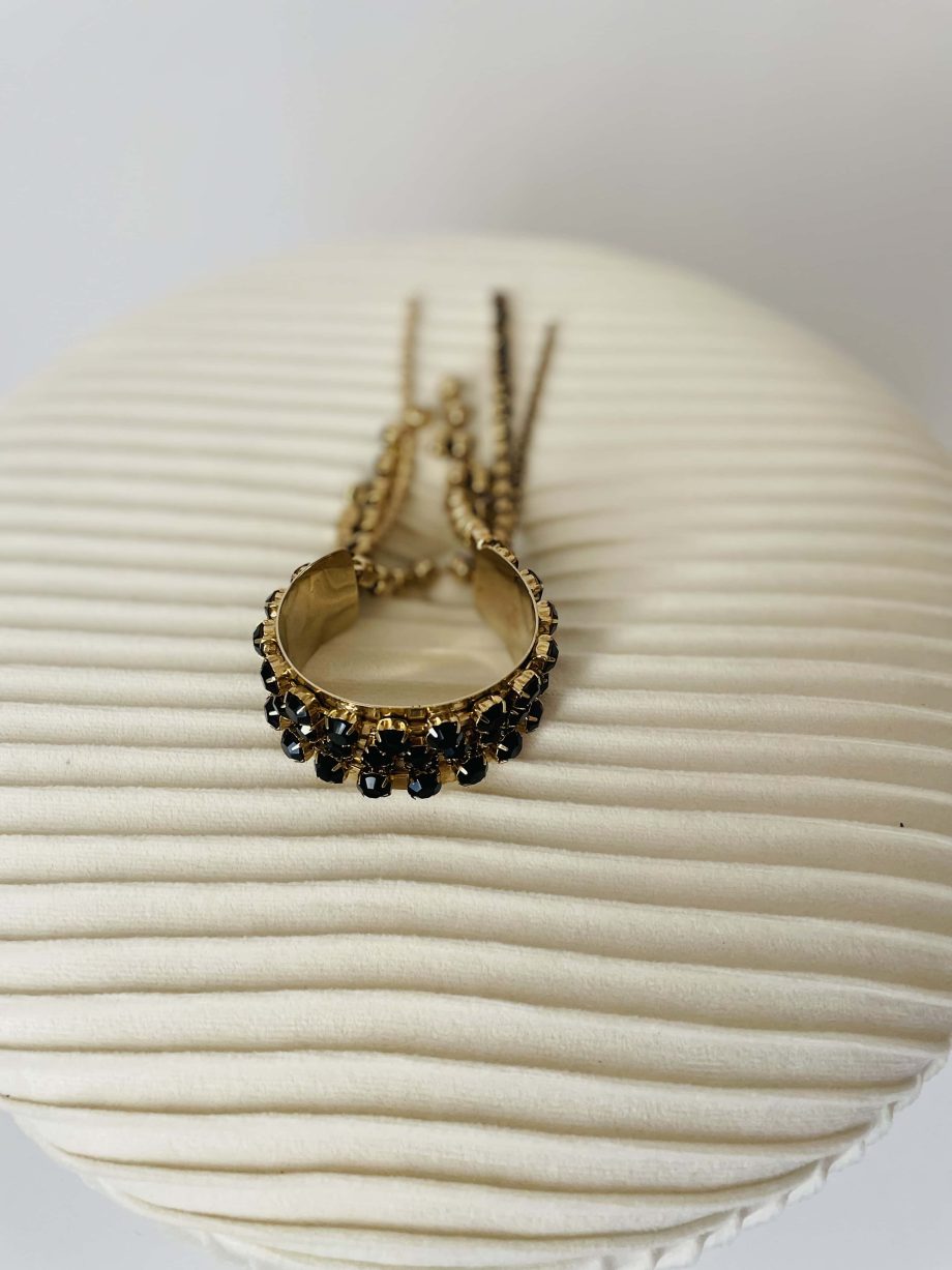 Bracciale rigido dorato con strass neri